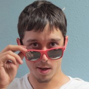 Dark-haired man with pink-framed mirrored sunglasses
